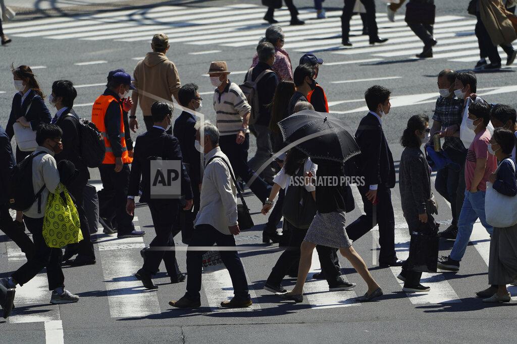 Eugene Hoshiko People wearing protective masks to help curb the spread of the coronavirus walk along a pedestrian crossing Wednesday, April 21, 2021, in Tokyo. The Japanese capital confirmed more than 840 new coronavirus cases on Wednesday. (AP Photo/Eugene Hoshiko)