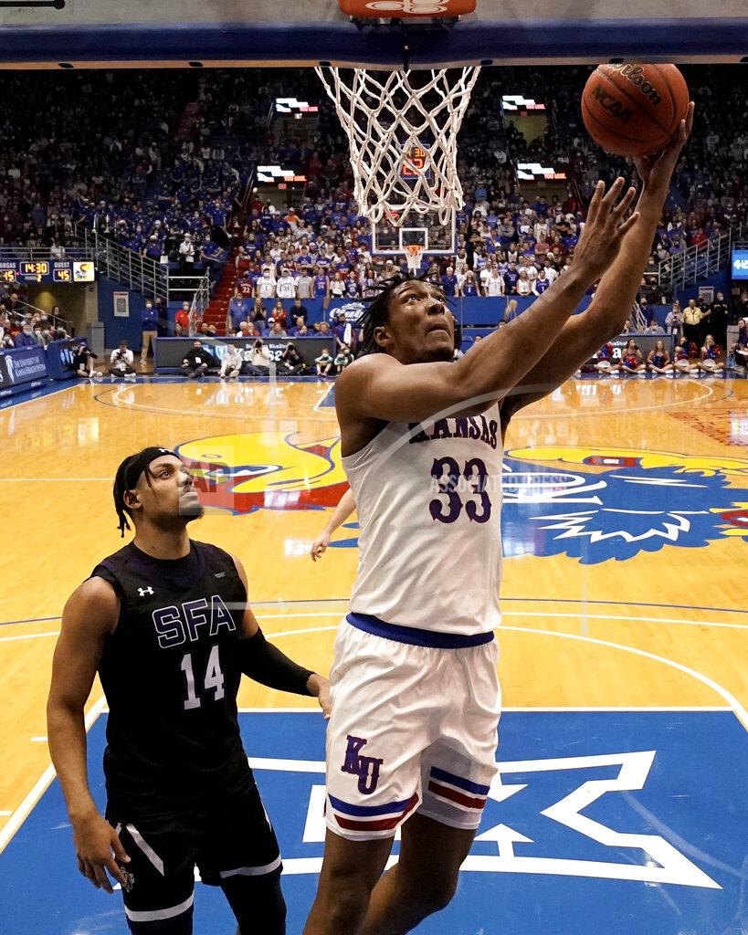 Charlie Riedel Kansas' David McCormack (33) gets past Stephen F. Austin's Gavin Kensmil (14) to put up a shot during the second half of an NCAA college basketball game Saturday, Dec. 18, 2021, in Lawrence, Kan. (AP Photo/Charlie Riedel)
