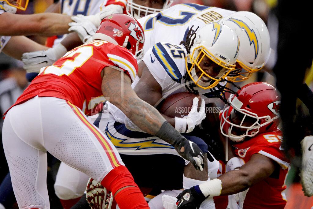 Charlie Riedel Los Angeles Chargers running back Melvin Gordon III (25) is tackled by Kansas City Chiefs linebacker Anthony Hitchens, left, and linebacker Reggie Ragland (59) during the first half of an NFL football game in Kansas City, Mo., Sunday, Dec. 29, 2019. (AP Photo/Charlie Riedel)