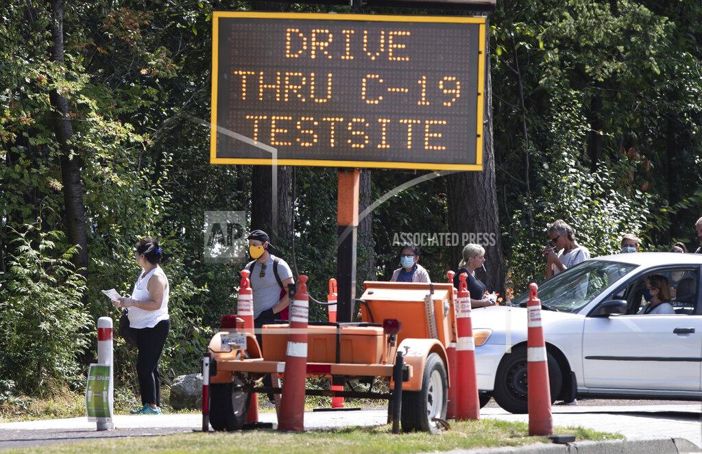 Darryl Dyck People wait in line at a COVID-19 testing facility during the coronavirus pandemic in Burnaby, British Columbia, on Thursday, Aug. 13, 2020. (Darryl Dyck/The Canadian Press via AP)