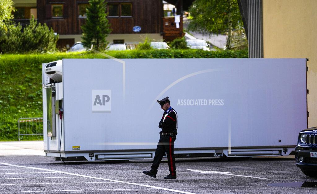 Luca Bruno A Carabinieri police officer walks by the refrigerated container where the bodies of the people who died under the Punta Rocca glacier avalanche are kept in Canazei, in the Italian Alps in northern Italy, Monday, July 4, 2022, a day after a huge chunk of the glacier broke loose, sending an avalanche of ice, snow, and rocks onto hikers. Rescuers said conditions downslope from the glacier, which has been melting for decades, were still too unstable to immediately send rescuers and dogs into the area to look for others buried under tons of debris. (AP Photo/Luca Bruno)
