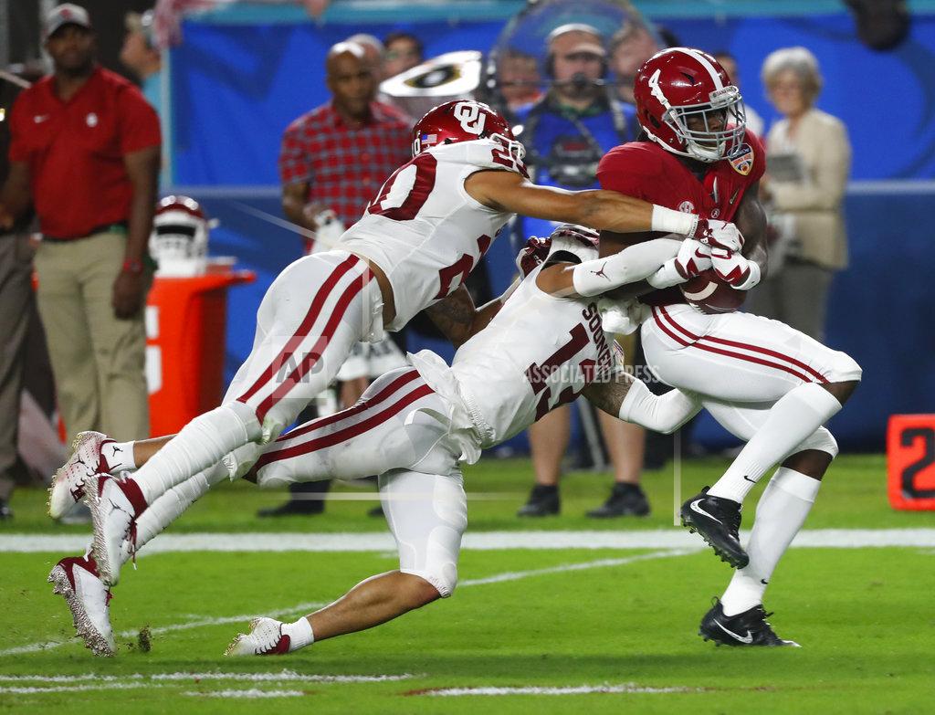 Wilfredo Lee Oklahoma safety Robert Barnes (20) and cornerback Tre Norwood (13) tackle Alabama wide receiver Jerry Jeudy (4), during the first half of the Orange Bowl NCAA college football game, Saturday, Dec. 29, 2018, in Miami Gardens, Fla. (AP Photo/Wilfredo Lee)