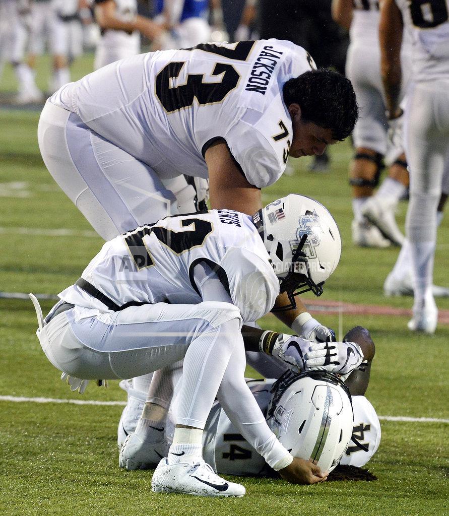 Mark Zaleski Central Florida defensive back Nevelle Clarke (14) lies on the field as he celebrates with Samuel Jackson (73) Rahsaan Lewis (42) after the team's win against Memphis in an NCAA college football game Saturday, Oct. 13, 2018, in Memphis, Tenn. Central Florida won 31-30. (AP Photo/Mark Zaleski)