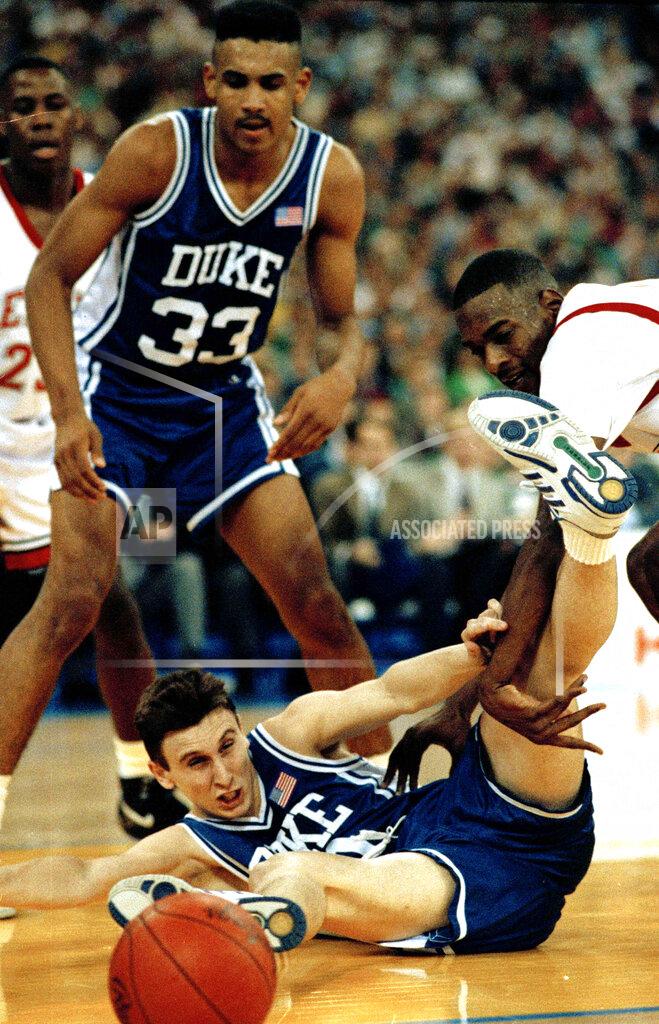 Ed Reinke FILE - In this May 30, 1991, file photo, Duke's Bobby Hurley goes to the floor after the basketball as Stacey Augmon of UNLV, right, and teammate Grant Hill watch in the semifinal game of the NCAA Final Four in Indianapolis, March 30, 1991. A panel of Associated Press sports writers voted this game as fifth on the list of top 10 men's basketball games in the history of the NCAA Tournament.(AP Photo/Ed Reinke, File)