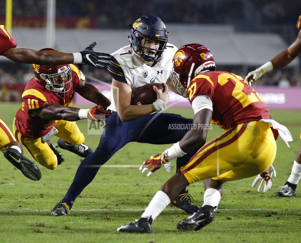 Alex Gallardo California quarterback Chase Garbers, center, eludes both Southern California linebacker John Houston Jr., left, and cornerback Ajene Harris, right, to score during the second half of an NCAA college football game in Los Angeles, Saturday, Nov. 10, 2018. California won 15-14. (AP Photo/Alex Gallardo)