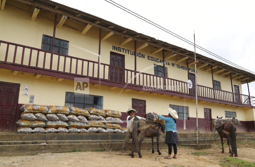 Martin Mejia A couple loads bags of potatoes on their horse outside the school where Free Peru party presidential candidate Pedro Castillo works as a teacher, and where local farms are storing their harvests while school is closed due to COVID-19, in Puna, Peru, Friday, April 16, 2021. Castillo, who has proposed rewriting Peru's constitution and deporting all immigrants living in the country illegally who commit crimes, will face rival candidate Keiko Fujimori in the June 6 presidential run-off election. (AP Photo/Martin Mejia)
