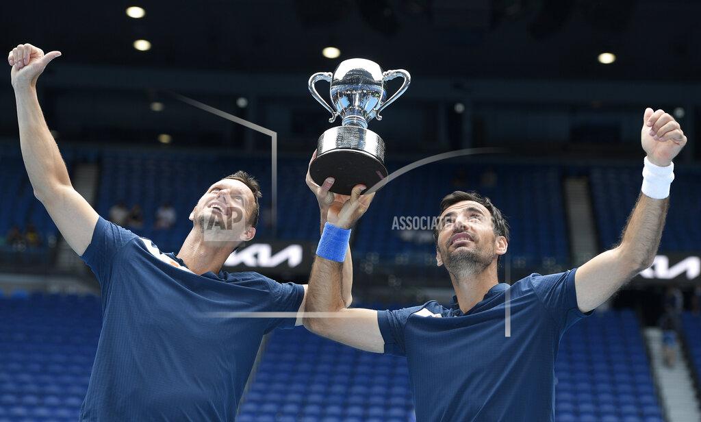 Andy Brownbill Croatia's Ivan Dodig, right, and Slovakia's Filip Polasek hold their trophy aloft after defeating Rajeev Ram of the US and Britain's Joe Salisbury in the men's doubles final at the Australian Open tennis championship in Melbourne, Australia, Sunday, Feb. 21, 2021.(AP Photo/Andy Brownbill)