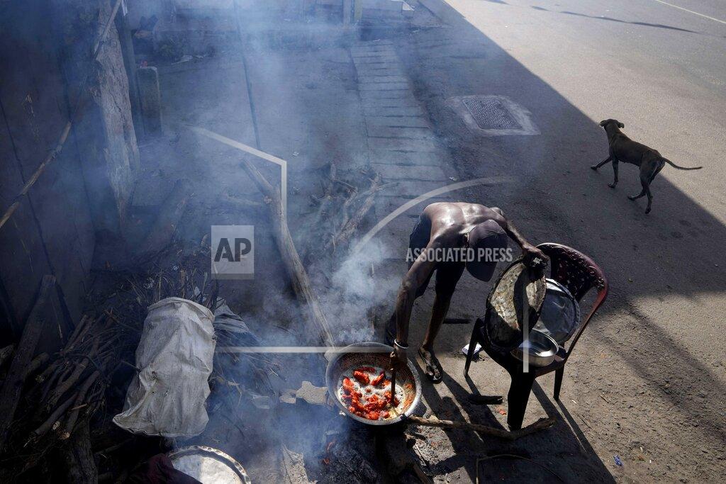 Eranga Jayawardena A man cooks food with firewood for his roadside eatery, amid shortage of cooking gas in Colombo, Sri Lanka, Thursday, June 23, 2022. Sri Lanka's prime minister says the island nation's debt-laden economy has "collapsed" as it runs out of money to pay for food and fuel. (AP Photo/Eranga Jayawardena)
