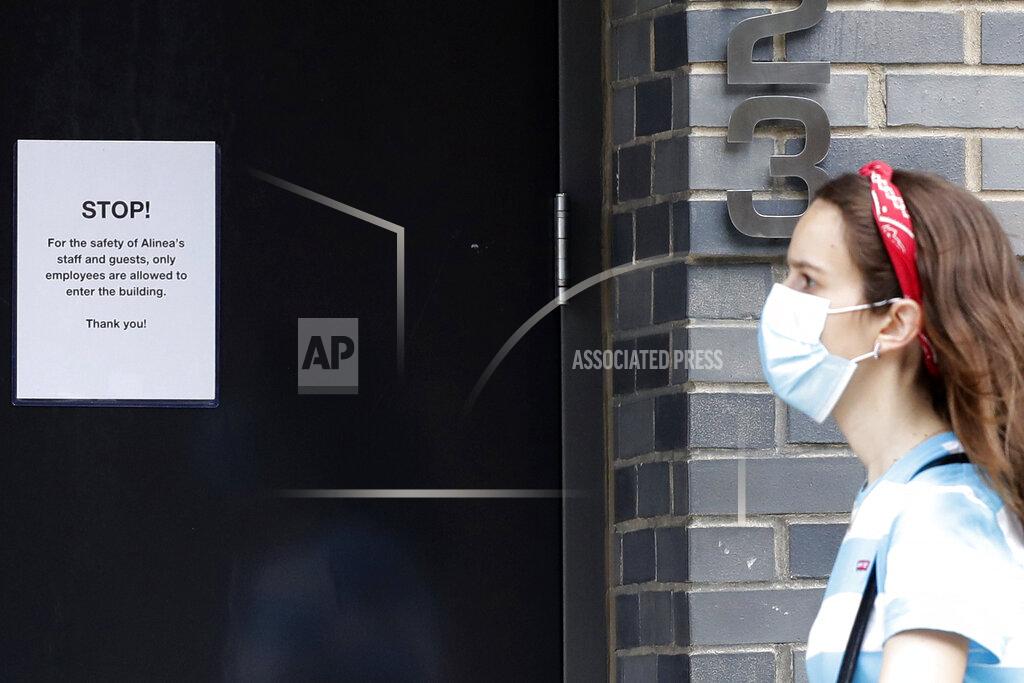 Nam Y. Huh A woman walks near a sign posted at Alinea restaurant in Chicago, Saturday, June 20, 2020. Some of the world's best restaurants have had to make a quick pivot to weather the coronavirus. Alinea used to offer an 18-course tasting menu for $365; now it's making carryout meals for $49.94. (AP Photo/Nam Y. Huh)