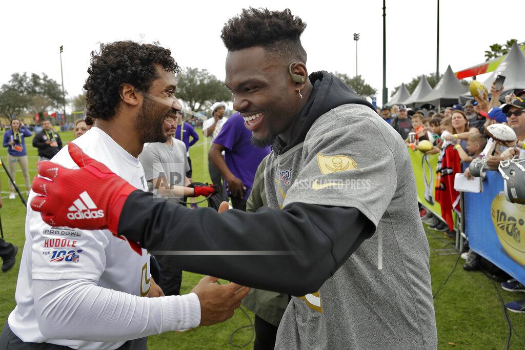 Chris O'meara NFC linebacker Shaquil Barrett, of the Tampa Bay Buccaneers,, right, shakes hands with quarterback Russell Wilson, of the Seattle Seahawks, after a practice for the NFL Pro Bowl football game Thursday, Jan. 23, 2020, in Kissimmee, Fla. (AP Photo/Chris O'Meara)