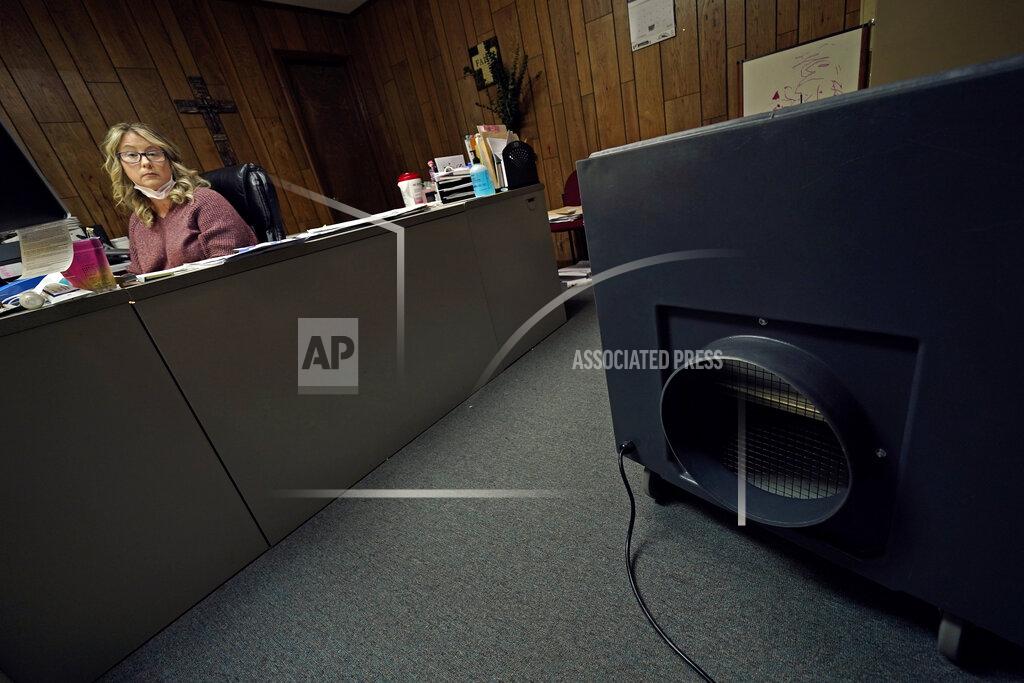 Charlie Riedel Tisha Coleman, public health administrator for Linn County, sits at her desk near a HEPA air filter in her office in Pleasanton, Kan., on Monday, Dec. 7, 2020. In this community with no hospital, she's failed to persuade her neighbors to wear masks and take precautions against COVID-19, even as cases rise. In return, she's been harassed, sued, vilified and called a Democrat, an insult in her circles. (AP Photo/Charlie Riedel)