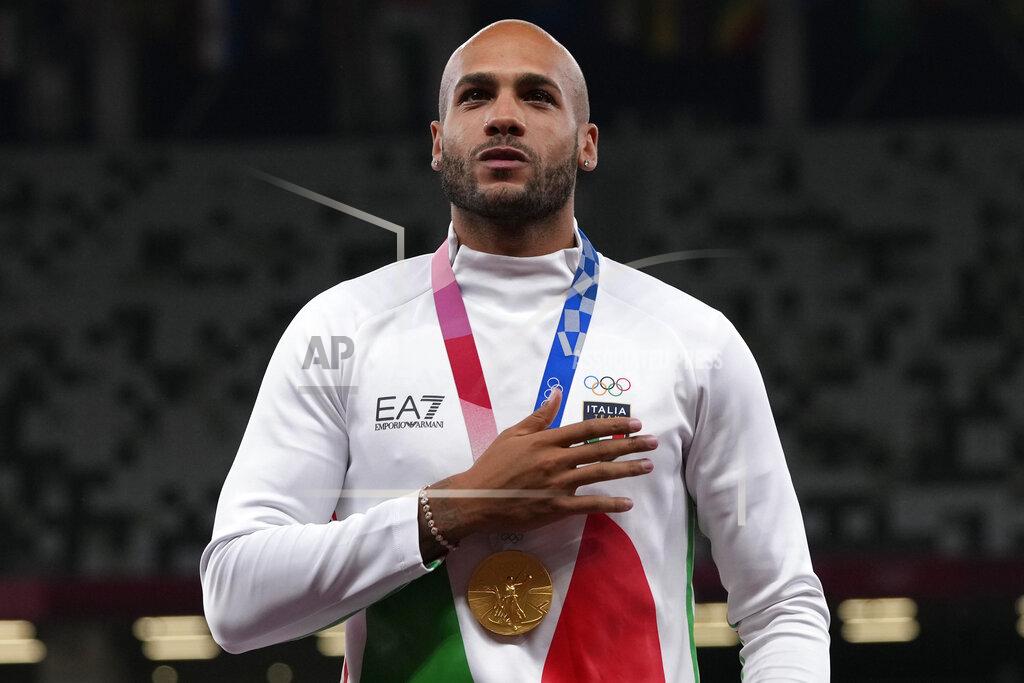 Lamont Marcell Jacobs, of Italy stands on the podium with his gold medal following the men's 100-meters final at the 2020 Summer Olympics, Monday, Aug. 2, 2021, in Tokyo. (AP Photo/Francisco Seco)