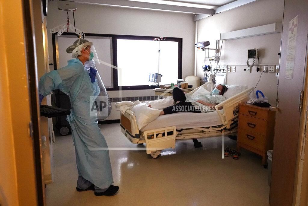 Elaine Thompson Registered nurse Lilyrose Fox, left, talks with coronavirus patient Shanon Walker in the COVID acute care unit at UW Medical Center-Montlake, Tuesday, Jan. 26, 2021, in Seattle. King County, where the hospital is located, has been on a downward trend of COVID-19 cases after two-and-a-half straight months of increases. But the current lull could be, and some experts believe will be, upended as more contagious variants of the virus spread throughout United States. (AP Photo/Elaine Thompson)