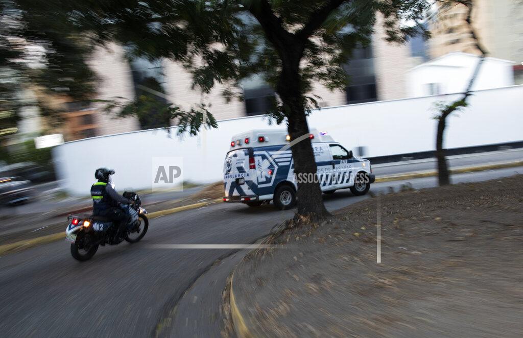Ariana Cubillos An Angels of the Road volunteer paramedic follows on a motorcycle their single ambulance transporting a patient who was injured in a road accident, in Caracas, Venezuela, Wednesday, Feb. 10, 2021. The volunteer group keeps a constant ear on walkie-talkie radio traffic and scan online chats dedicated to emergency services. (AP Photo/Ariana Cubillos)