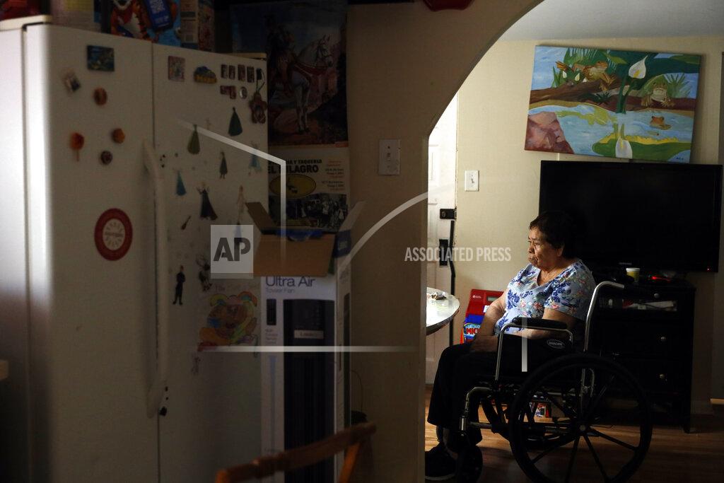 Shafkat Anowar Francisca Perez, 84, sits by the dining table on a wheelchair in her house in Chicago's Little Village neighborhood, Wednesday, June 30, 2021. She suffers from a heart condition, rheumatoid arthritis and depression, among other ailments. Her daughter, Eugenia Rodriguez, hasn't been eligible for insurance coverage after overstaying a visitor visa from Mexico. She used to wake up every two or three hours at night to check on her mother. Since getting health insurance through the Illinois program, her mother has all the medications she needs. (AP Photo/Shafkat Anowar)