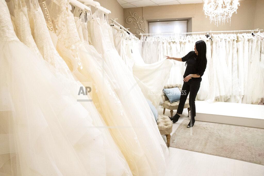 Alessandra Tarantino Anita Galafate checks wedding dresses in a shop in Rome, Tuesday, March 9, 2021. Self-employed wedding planner Anita Galafate, 38, saw nearly all her business evaporate in the pandemic. Worldwide, working women paid a high price during the pandemic as many quit jobs to care for children when schools closed. But Italy's women went into the crisis already struggling for decades to expand their presence in the national workforce. Among the 27 European Union nations, Italian women rank next to the bottom, after Greek women, in terms of percentage in national workforces. Among young women, Italians rank the lowest. (AP Photo/Alessandra Tarantino)