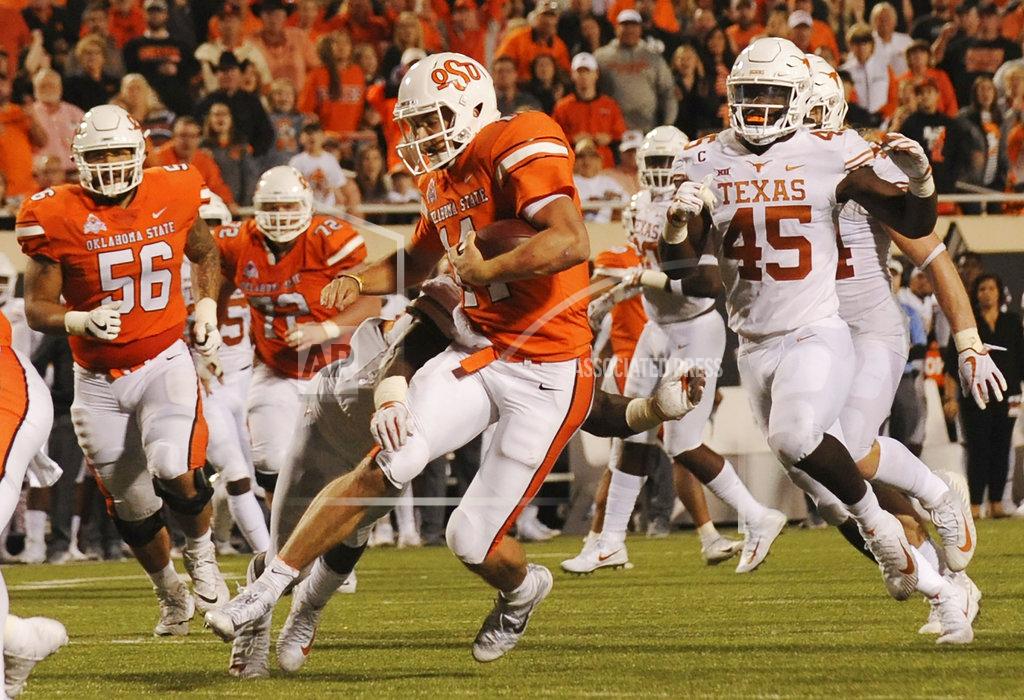 Brody Schmidt Oklahoma State offensive lineman Larry Williams (56) watches as Oklahoma State quarterback Taylor Cornelius (14) runs for the end zone while under pressure by Texas linebacker Anthony Wheeler (45) in the second half of an NCAA college football game in Stillwater, Okla., Saturday, Oct. 27, 2018. Oklahoma State defeated Texas 38-35. (AP Photo/Brody Schmidt)