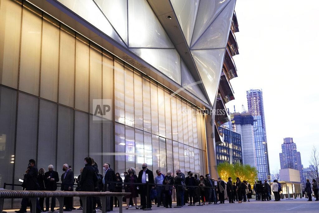 Kathy Willens People line up outside The Shed before a live performance by the New York Philharmonic, whose members performed together for the first time since March 2020, on Wednesday, April 14, 2021, at Hudson Yards in New York. Normal subscription performances are to resume in September. (AP Photo/Kathy Willens)