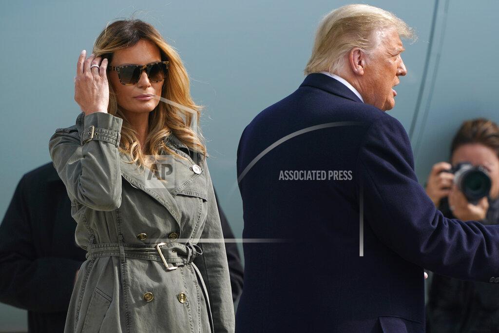 Susan Walsh President Donald Trump talks with the traveling press as first lady Melania Trump waits near Air Force One at Andrews Air Force Base, Md., Tuesday, Oct. 27, 2020. They flew together on Marine One to Andrews Air Force Base but are traveling on different planes to campaign separately. (AP Photo/Susan Walsh)