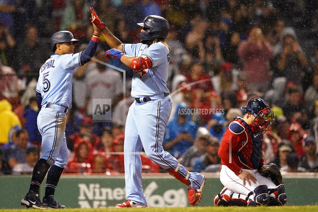 Elise Amendola Toronto Blue Jays' Vladimir Guerrero Jr., center, celebrates his three-run home run with Santiago Espinal (5) as Boston Red Sox catcher Christian Vazquez looks at the ground during the fifth inning of a baseball game at Fenway Park, Thursday, July 29, 2021, in Boston. (AP Photo/Elise Amendola)