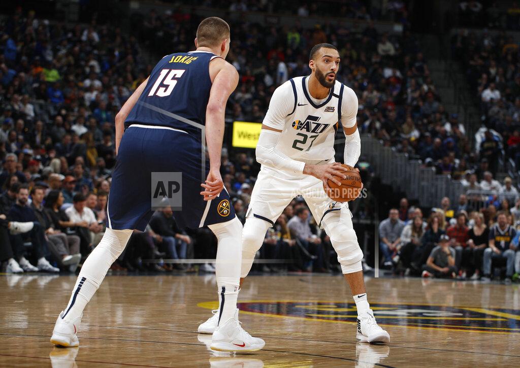 David Zalubowski FILE - In this Thursday, Jan. 30, 2020, file photo Utah Jazz center Rudy Gobert, right, looks to pass the ball as Denver Nuggets center Nikola Jokic defends in the second half of an NBA basketball game in Denver. (AP Photo/David Zalubowski, File)
