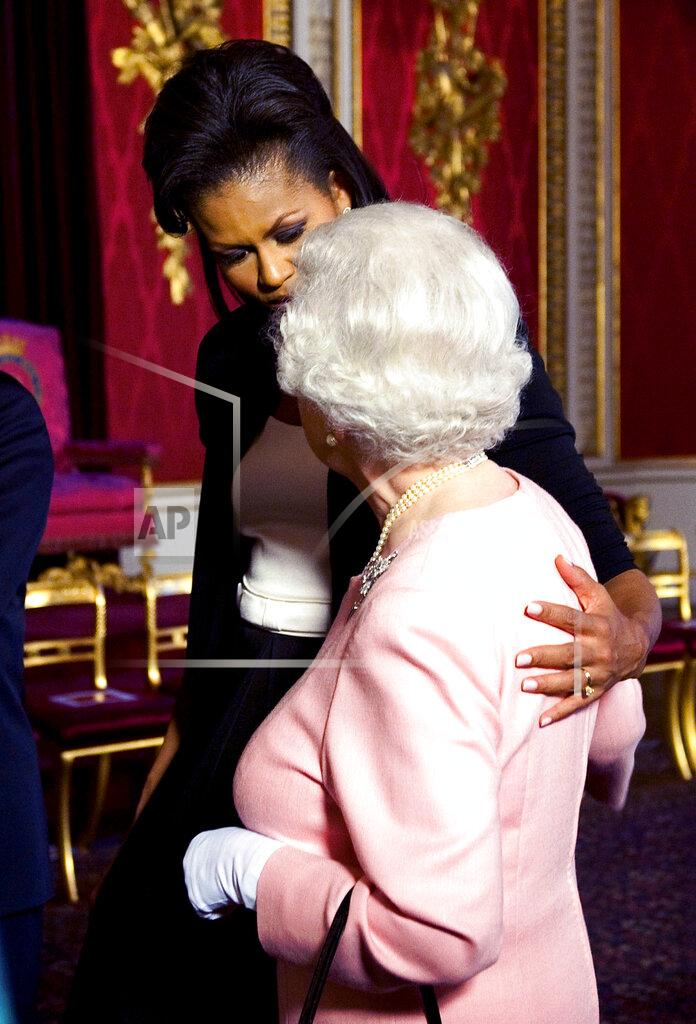 Daniel Hambury FILE - In this April 1, 2009 file photo, Michelle Obama, wife of U.S. President Barack Obama, left, walks with Queen Elizabeth II at the reception at Buckingham Palace in London. (Daniel Hambury/Pool Photo via AP, File)