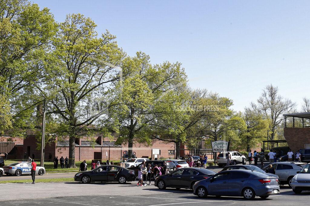 Wade Payne People gather outside Austin-East Magnet High School in Knoxville, Tenn., as Knoxville police work the scene following a shooting at the school Monday, April 12, 2021. (AP Photo/Wade Payne)