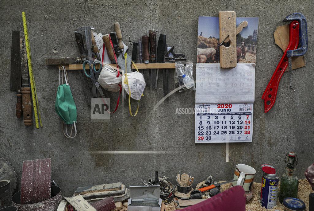 Esteban Felix The tools of the trade hand from a rack on a wall at the Bergut Funeral Services in Santiago, Chile, Thursday, June 18, 2020. The coffin production has had to increase up to 120%, according to Nicolas Bergerie, owner of the factory. His more basic coffin model is called the COVID model and is made to cope with the increase of deaths during the coronavirus pandemic. (AP Photo/Esteban Felix)