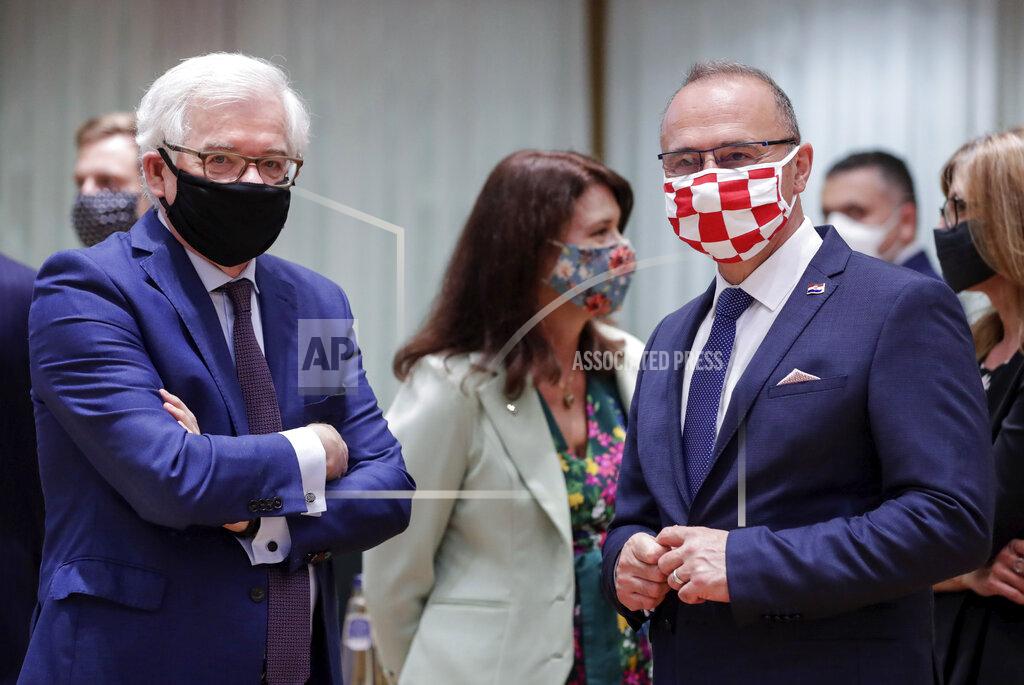 Stephanie Lecocq Poland's Foreign Minister Jacek Czaputowicz, left, and Croatia's Foreign Minister Gordan Grlic Radman, right, wear protective face mask, to prevent against the spread of coronavirus, as they attend a meeting of EU foreign ministers at the European Council building in Brussels, Monday, July 13, 2020. European Union foreign ministers meet for the first time face-to-face since the pandemic lockdown and will assess their discuss their relations with China and Turkey. (Stephanie Lecocq, Pool Photo via AP)