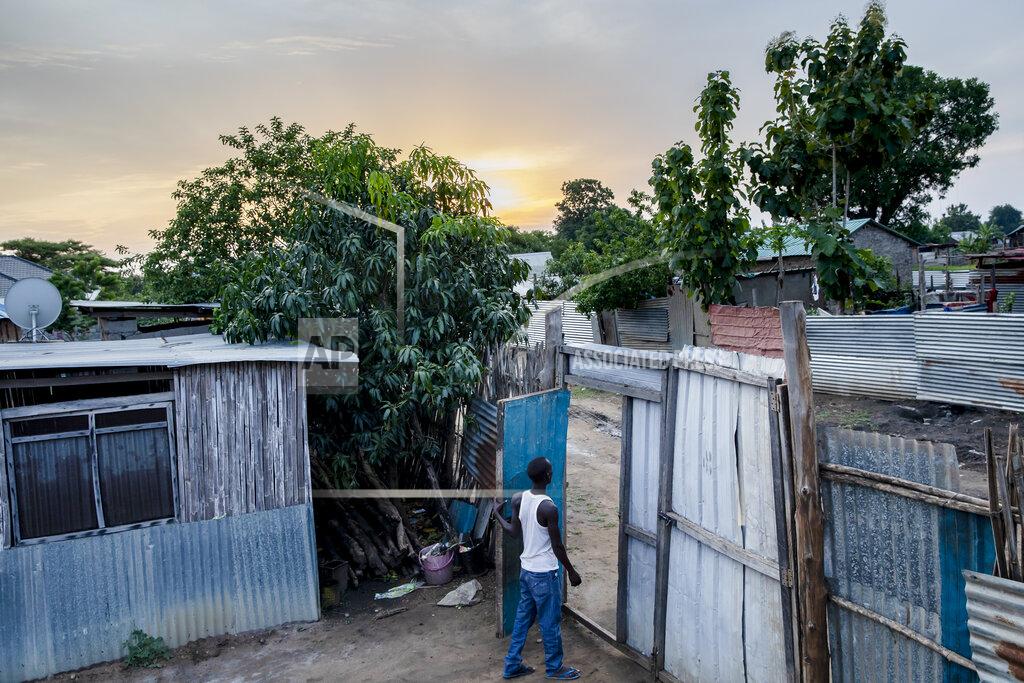 Adrienne Surprenant Paska Itwari Beda's neighbour opens his gate in Juba, South Sudan Thursday, May 27, 2021. Even before the pandemic hit, South Sudanese women were accustomed to building lives on the edge of uncertainty. But COVID-19 is shaking that fragile foundation. The country is just a decade old and one of the world's most difficult places to raise children. (AP Photo/Adrienne Surprenant)