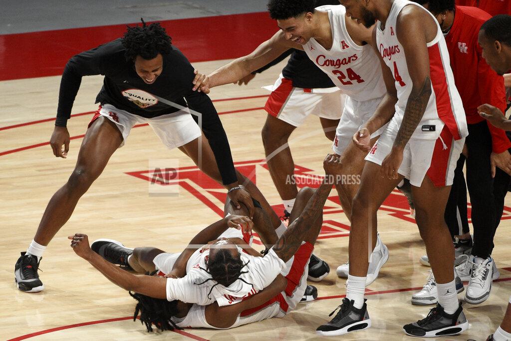 Eric Christian Smith Houston guard Tramon Mark, bottom, celebrates his game-winning 3-point basket with teammates during the second half of an NCAA college basketball game against Memphis, Sunday, March 7, 2021, in Houston. (AP Photo/Eric Christian Smith)