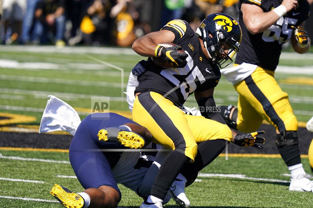 Charlie Neibergall Iowa running back Gavin Williams (25) is tackled by Michigan linebacker Taylor Upshaw (91) after catching a pass during the first half of an NCAA college football game, Saturday, Oct. 1, 2022, in Iowa City, Iowa. (AP Photo/Charlie Neibergall)