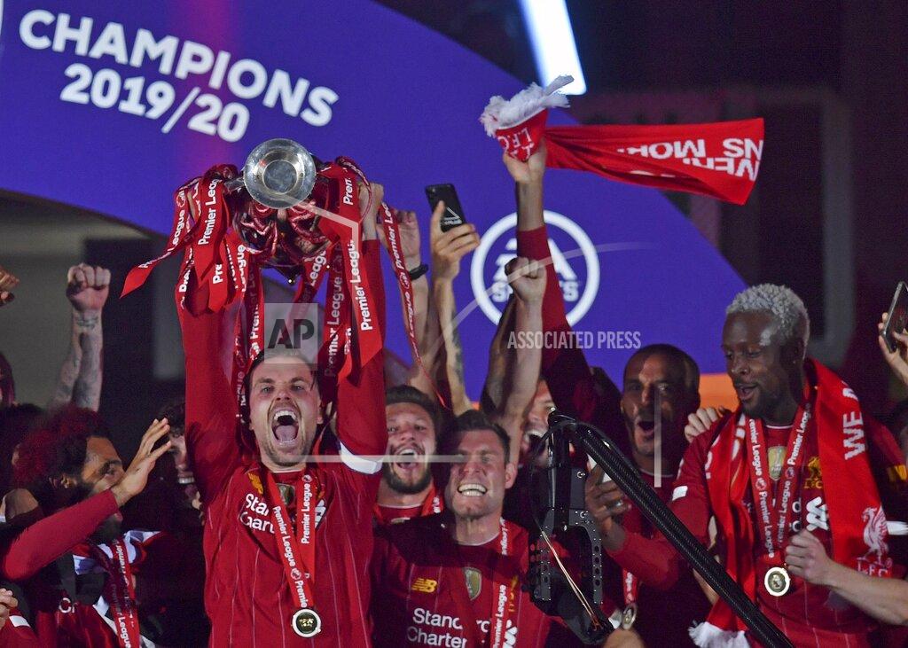 Paul Ellis Liverpool's Jordan Henderson holds the English Premier League trophy aloft after it was presented following the Premier League soccer match between Liverpool and Chelsea at Anfield stadium in Liverpool, England, Wednesday, July 22, 2020. (Paul Ellis, Pool via AP)