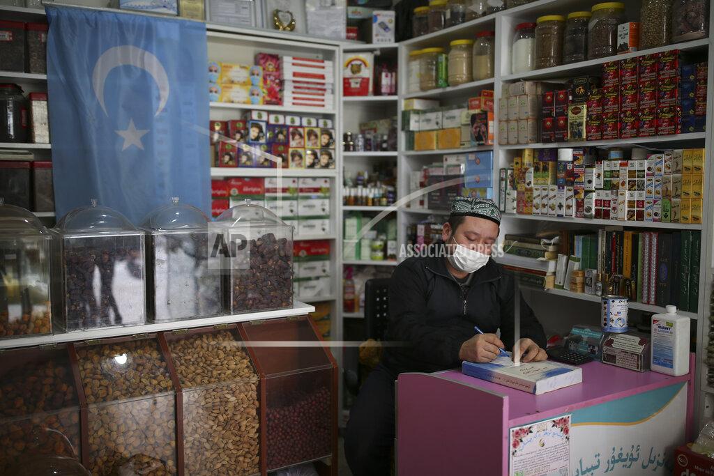 Emrah Gurel Ahmed Hasim, a member of the Uighur community, takes notes in his grocery store, in Istanbul's Zeytinburnu neighborhood, Tuesday, Feb. 2, 2021. Because of shared cultural ties, Turkey has long been a safe haven for the Uighurs, a Turkic group native to China's far west Xinjiang region. Opposition legislators in Turkey are accusing Ankara's leaders of secretly selling out Uighurs to China in exchange for coronavirus vaccines. (AP Photo/Emrah Gurel)