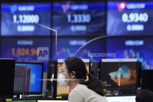 A currency trader watches monitors at the foreign exchange dealing room of the KEB Hana Bank headquarters in Seoul, South Korea, Thursday, Nov. 25, 2021. Asian stock markets fell Thursday after Federal Reserve officials indicated they were ready to raise interest rates sooner than expected if needed to cool inflation.(AP Photo/Ahn Young-joon)