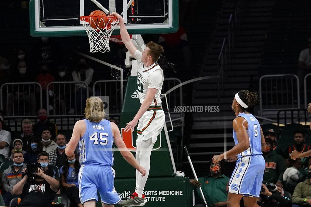 Lynne Sladky Miami forward Sam Waardenburg (21) dunks over North Carolina forward Brady Manek (45) and forward Armando Bacot (5) during the first half of an NCAA college basketball game, Tuesday, Jan. 18, 2022, in Coral Gables, Fla. (AP Photo/Lynne Sladky)