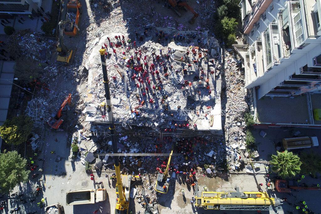 Uncredited Photo taken with a drone shows rescue workers trying to save residents trapped in debris of a collapsed building, in Izmir, Turkey, Saturday, Oct. 31, 2020. Rescue teams on Saturday ploughed through concrete blocs and debris of eight collapsed buildings in search of survivors of a powerful earthquake that struck Turkey's Aegean coast and north of the Greek island of Samos, leaving unknown numbers of dead and injured. (IHA via AP)