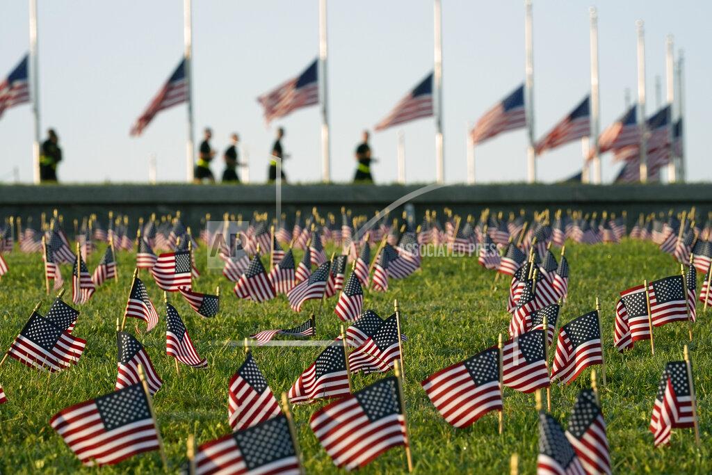 J. Scott Applewhite Activists from the COVID Memorial Project mark the deaths of 200,000 lives lost in the U.S. to COVID-19 after placing thousands of small American flags on the grounds of the National Mall in Washington, Tuesday, Sept. 22, 2020. (AP Photo/J. Scott Applewhite)
