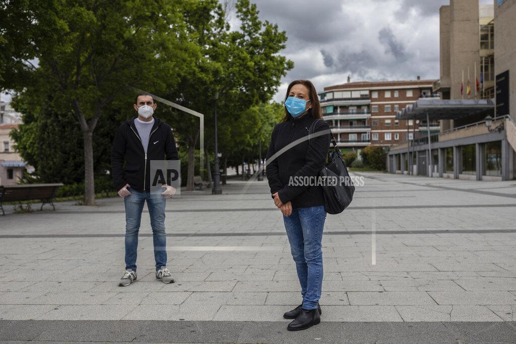 In this Friday, May 15, 2020 photo, María Mendoza, right, and Jose Manuel Martin, left, workers at the Usera Center for the Elderly, pose for portrait in Madrid, Spain. Workers at the Usera nursing home, Mendoza and Martin spoke about cost cutting and staff cuts at the Madrid nursing home where 42 people died. (AP Photo/Bernat Armangue)
