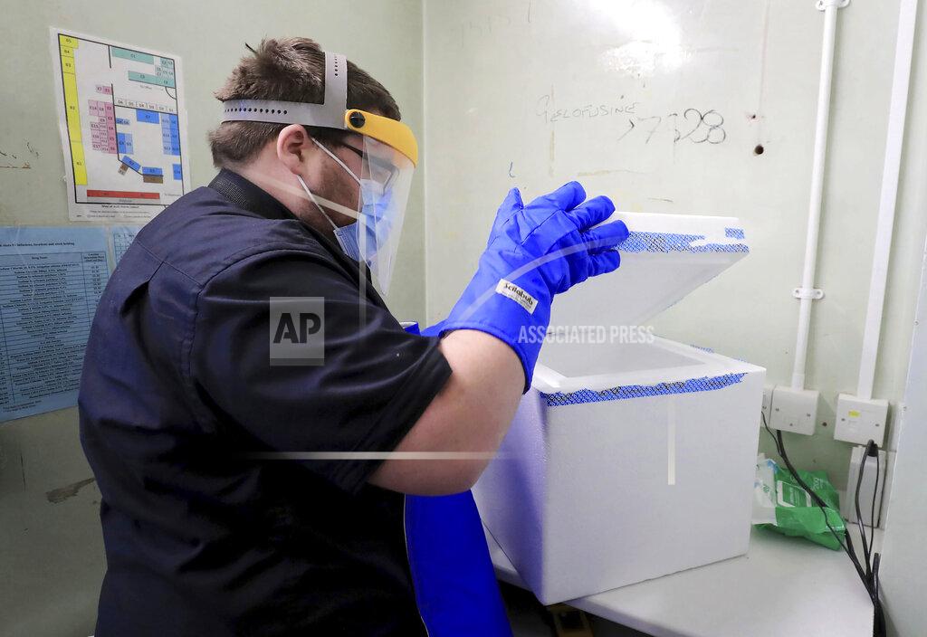 Gareth Fuller A pharmacy technician from Croydon Health Services prepares to store the first delivery of COVID-19 vaccine at Croydon University Hospital in Croydon, England, Saturday Dec. 5, 2020. The first batch of Pfizer COVID-19 vaccine is delivered to the area in preparation for public dispersal. (Gareth Fuller/Pool via AP)