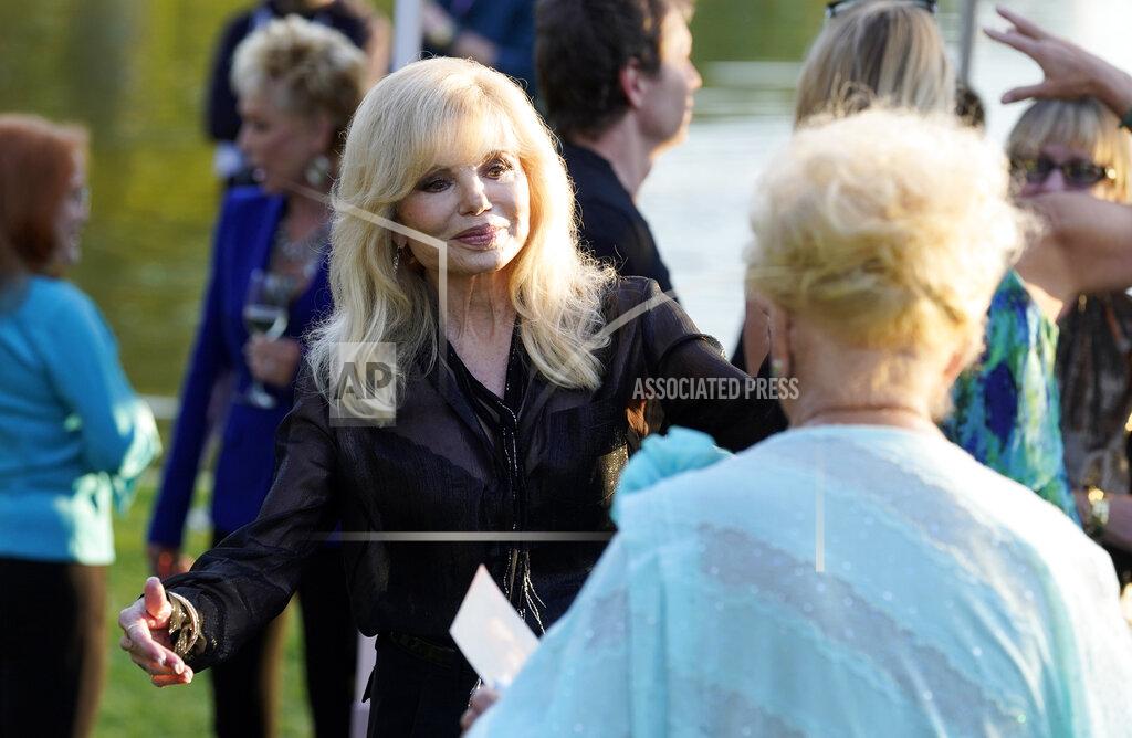Chris Pizzello Actress Loni Anderson, the former wife of the late actor Burt Reynolds, greets actress Ruta Lee, foreground, at the unveiling of a memorial sculpture of Reynolds at Hollywood Forever Cemetery, Monday, Sept. 20, 2021, in Los Angeles. Reynolds died in 2018 at the age of 82. (AP Photo/Chris Pizzello)
