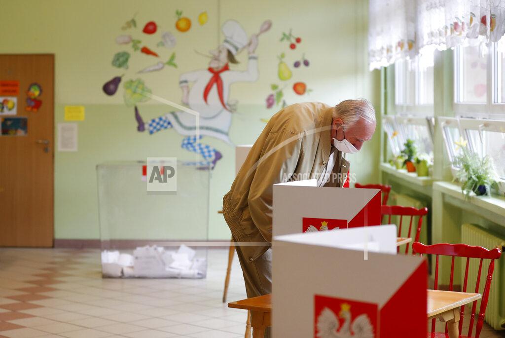 Petr David Josek A man prepares to cast his vote during the presidential election runoff in Rybnik, Poland, Sunday, July 12, 2020. Voting started Sunday in Poland's razor-blade-close presidential election runoff between the conservative incumbent Andrzej Duda and liberal, pro-European Union Warsaw Mayor Rafal Trzaskowski. (AP Photo/Petr David Josek)
