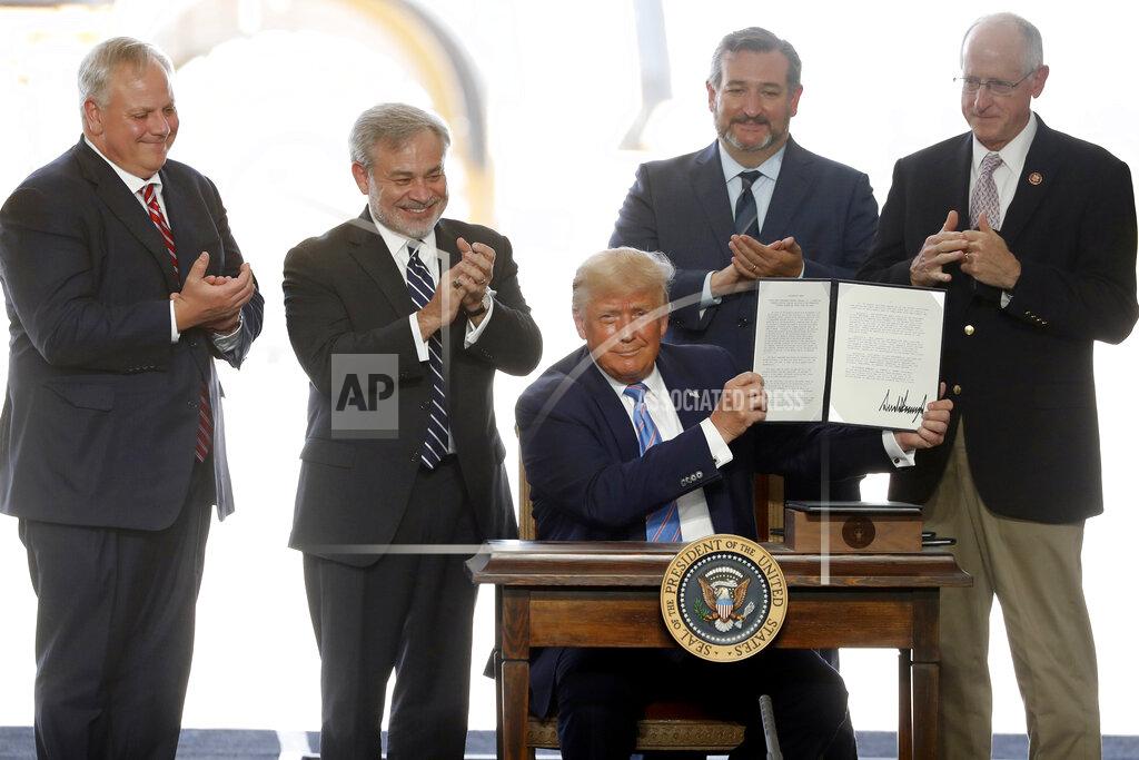 Tony Gutierrez President Donald Trump holds up a permit for energy development after signing it during a visit to the Double Eagle Energy Oil Rig, Wednesday, July 29, 2020, in Midland, Texas. Sen. Ted Cruz, R-Texas, stands rear, second from right. (AP Photo/Tony Gutierrez)