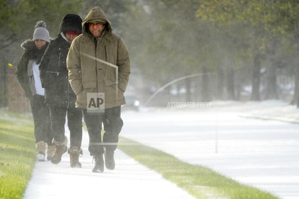 David J. Phillip Erasmo Vazquez, right, walks along a snow covered sidewalk with his wife, Maria, center, and daughter Day, left, Monday, Feb. 15, 2021, in Houston. A winter storm dropping snow and ice sent temperatures plunging across the southern Plains, prompting a power emergency in Texas a day after conditions canceled flights and impacted traffic across large swaths of the U.S. (AP Photo/David J. Phillip)