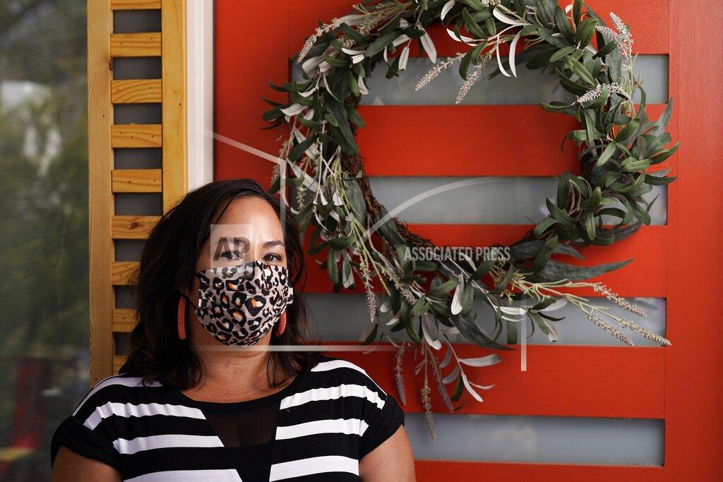 Lisa Phillips at her home Tuesday, April 20, 2021, in Phoenix. When the anniversary of the pandemic arrived, Phillips was not eager for a trip down memory lane. The Phoenix woman had developed symptoms and quarantined with a suspected case of COVID-19 last spring, lost her mother to the disease in July, and been hospitalized herself in November, overwhelmed by grief and isolation. (AP Photo/Ross D. Franklin)