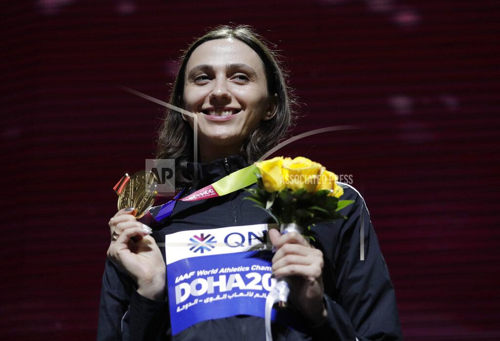 FILE - In this Tuesday, Oct. 1, 2019 file photo, Gold medalist Mariya Lasitskene, who participates as a neutral athlete, poses during the medal ceremony for the women's high jump at the World Athletics Championships in Doha, Qatar. Three-time world high jump champion Mariya Lasitskene has assailed Russian track leaders after they were charged with using fake medical documents during an investigation. Lasitskene has called for swift and radical reforms and the removal of officials appointed by track federation president Dmitry Shlyakhtin. (AP Photo/Nariman El-Mofty, File)