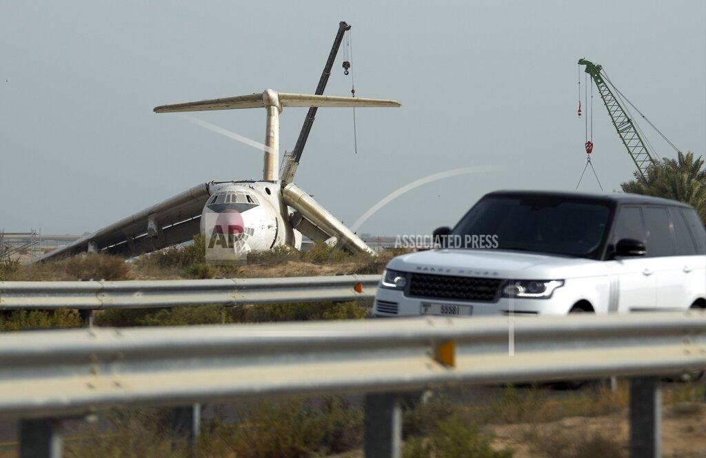 Kamran Jebreili A car passes by an abandoned plane, Ilyushin Il-76, once tied to arms smuggler Viktor Bout, being dismantled at the old airfield of Umm al-Quwain, United Arab Emirates, Friday, May 27, 2022. The hulking, Soviet-era cargo plane has sat for decades under the blazing sun in this least-populated corner of the United Arab Emirates, its four jet engines silent after years in the employ of a Russian gunrunner infamously known as the "Merchant of Death." (AP Photo/Kamran Jebreili)
