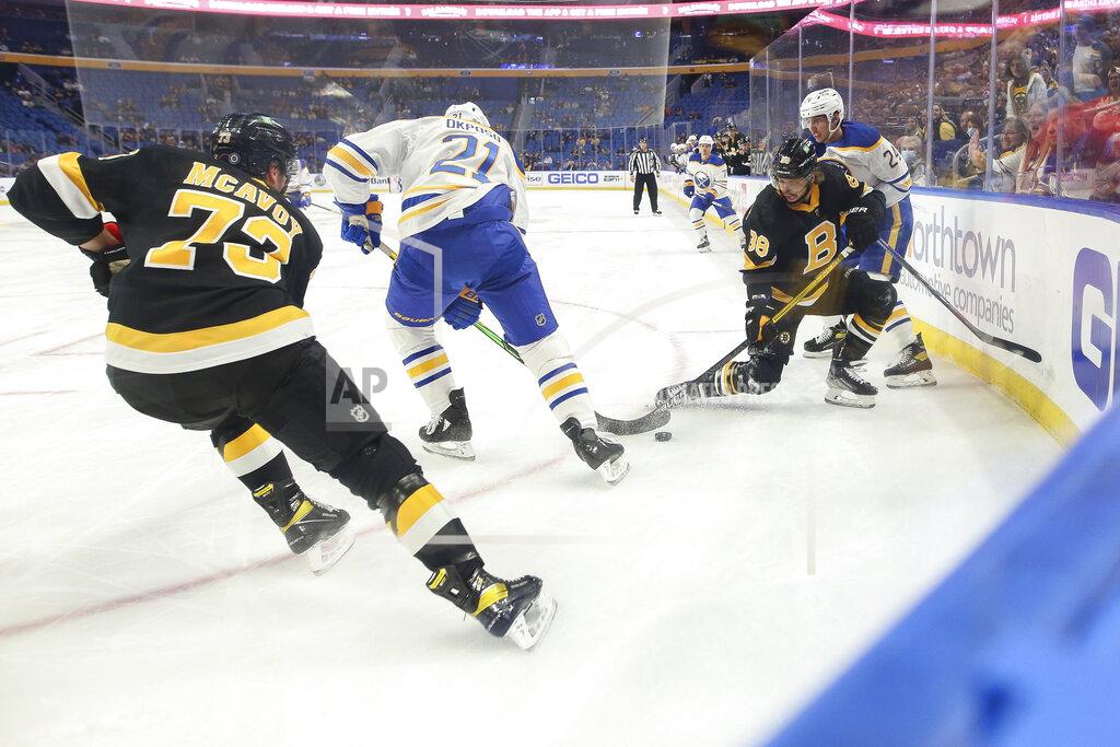 Joshua Bessex Buffalo Sabres right wing Kyle Okposo (21) and Boston Bruins right wing David Pastrnak (88) battle for possession of the puck during the second period of an NHL hockey game Friday, Oct. 22, 2021, in Buffalo, N.Y. (AP Photo/Joshua Bessex)