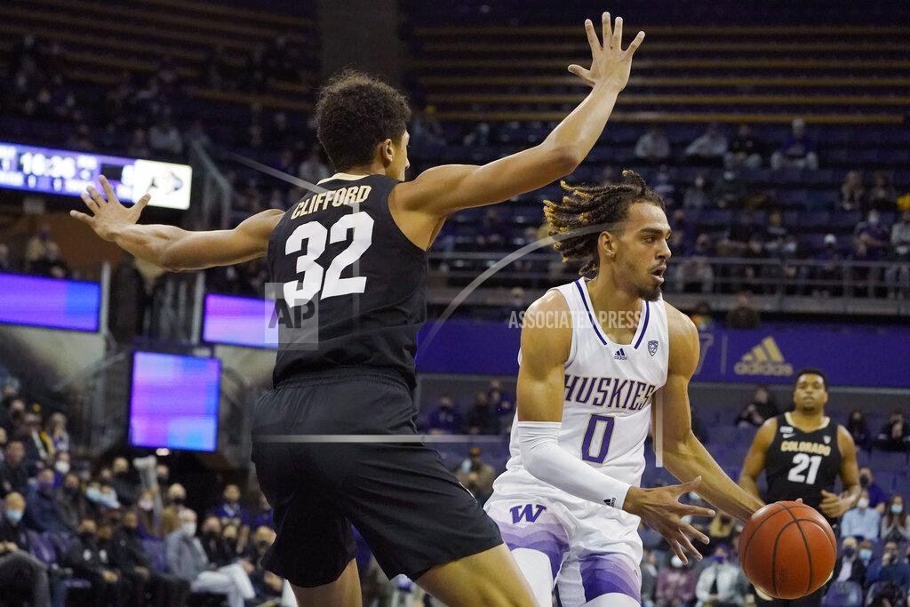 Ted S. Warren Washington forward Emmitt Matthews Jr. (0) looks to pass around Colorado guard Nique Clifford (32) during the first half of an NCAA college basketball game, Thursday, Jan. 27, 2022, in Seattle. (AP Photo/Ted S. Warren)