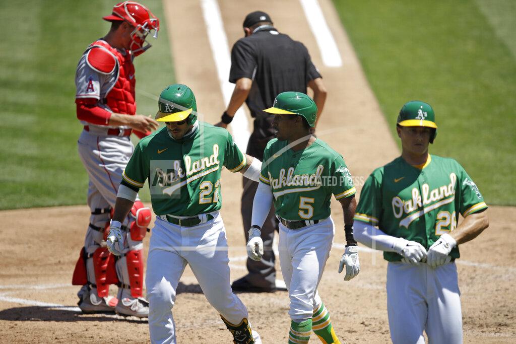 Ben Margot Oakland Athletics' Tony Kemp (5) is congratulated by Ramon Laureano (22) and Matt Olson, right, and Kemp scored on a sacrifice fly by Laureano during the third inning of the team's baseball game against the Los Angeles Angels on Monday, July 27, 2020, in Oakland, Calif. (AP Photo/Ben Margot)